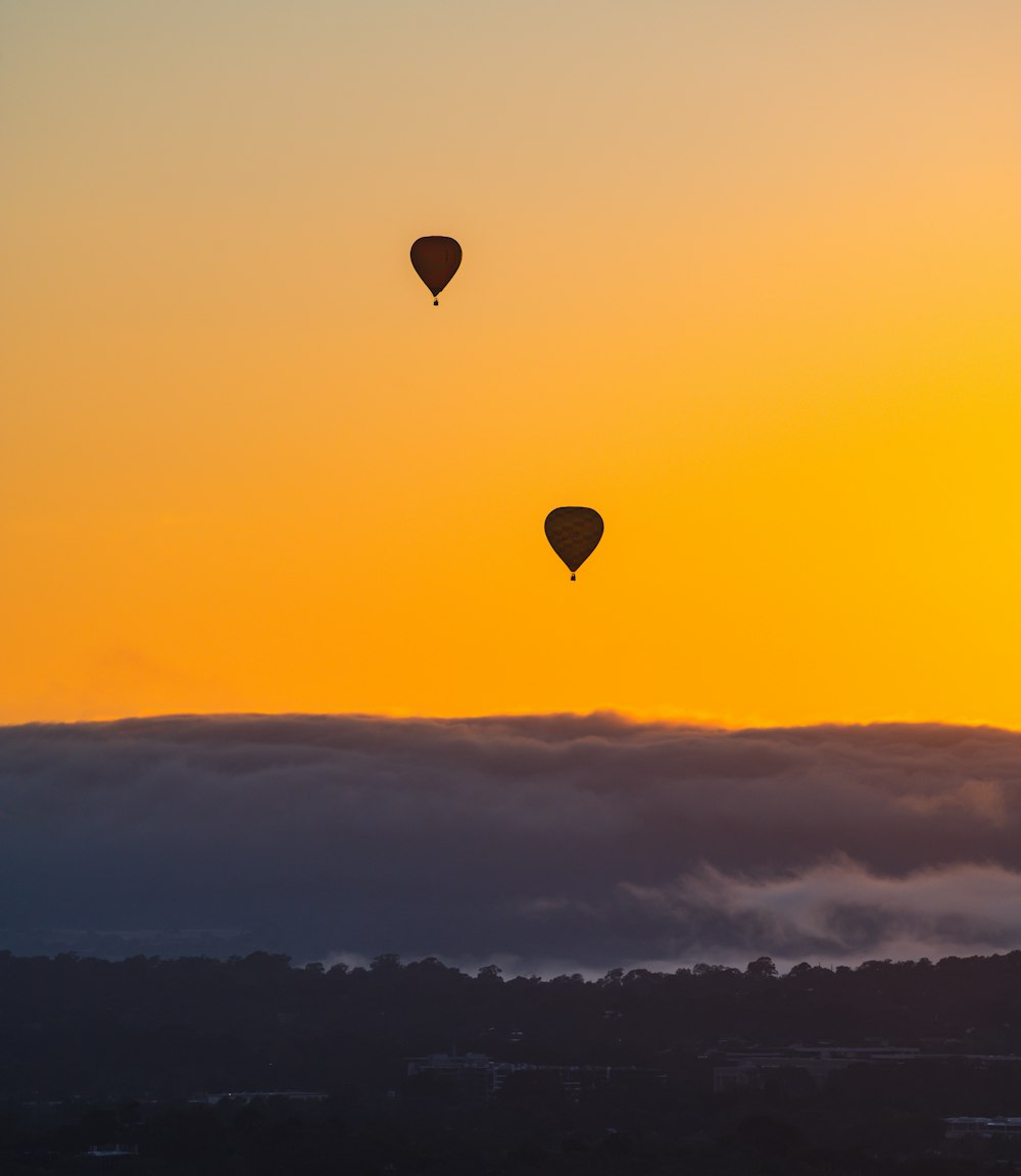 a couple of hot air balloons in the sky