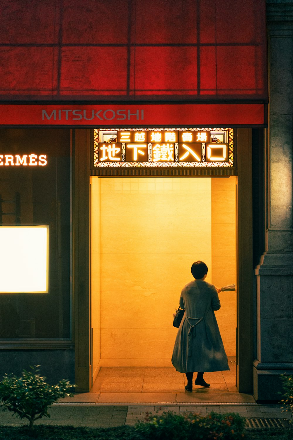 a person standing in front of a building with a sign on it