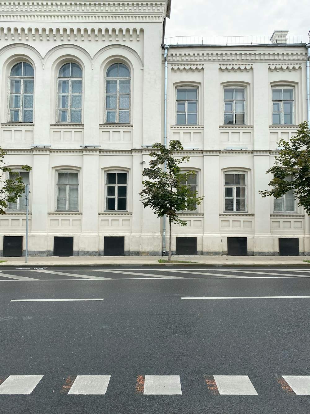 a large white building with a tree in front of it