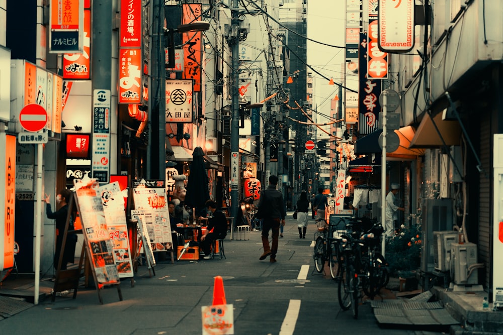 a man walking down a street next to tall buildings