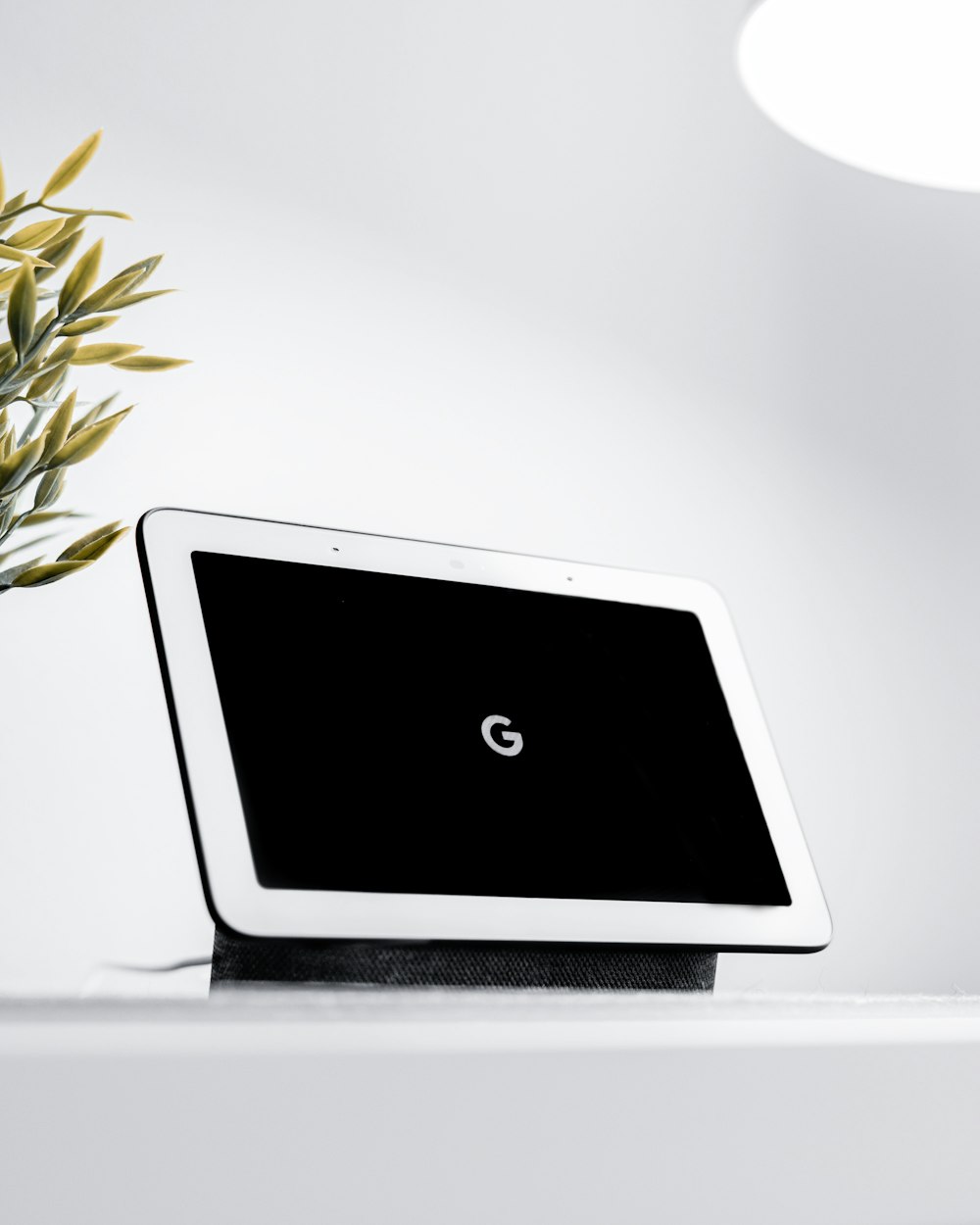 a tablet sitting on top of a table next to a plant