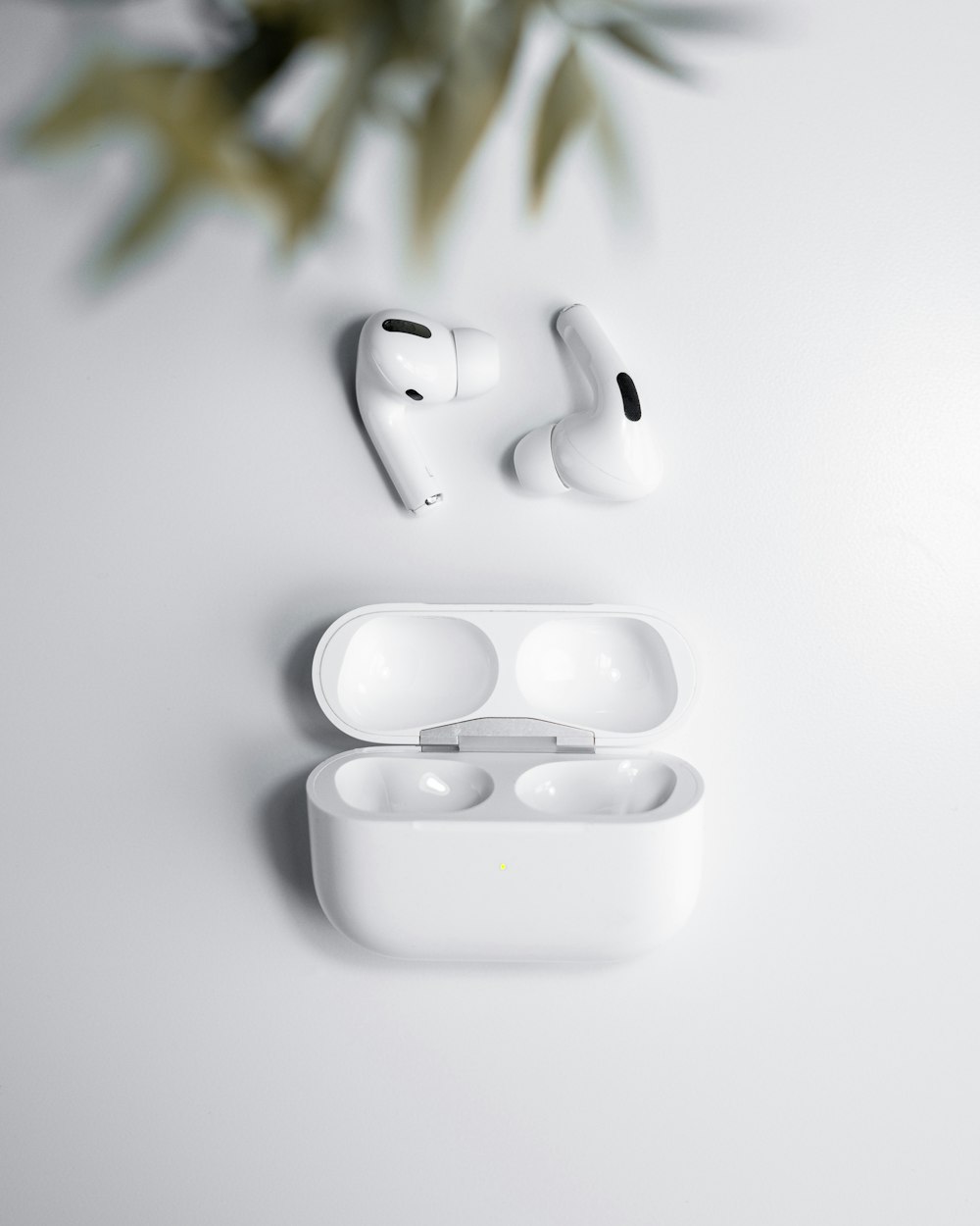 Un par de auriculares blancos sentados encima de una mesa