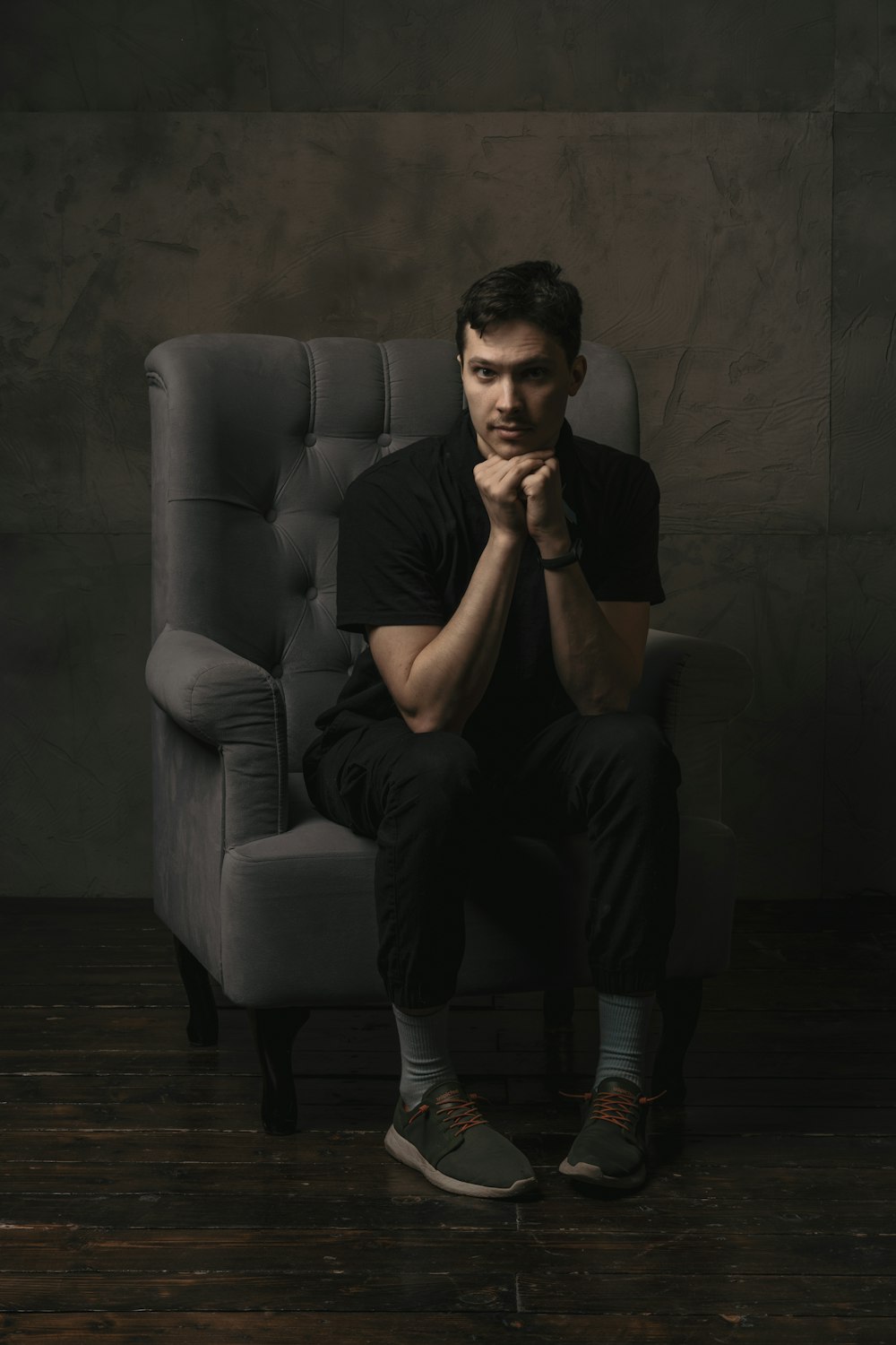a man sitting on a chair in a dark room