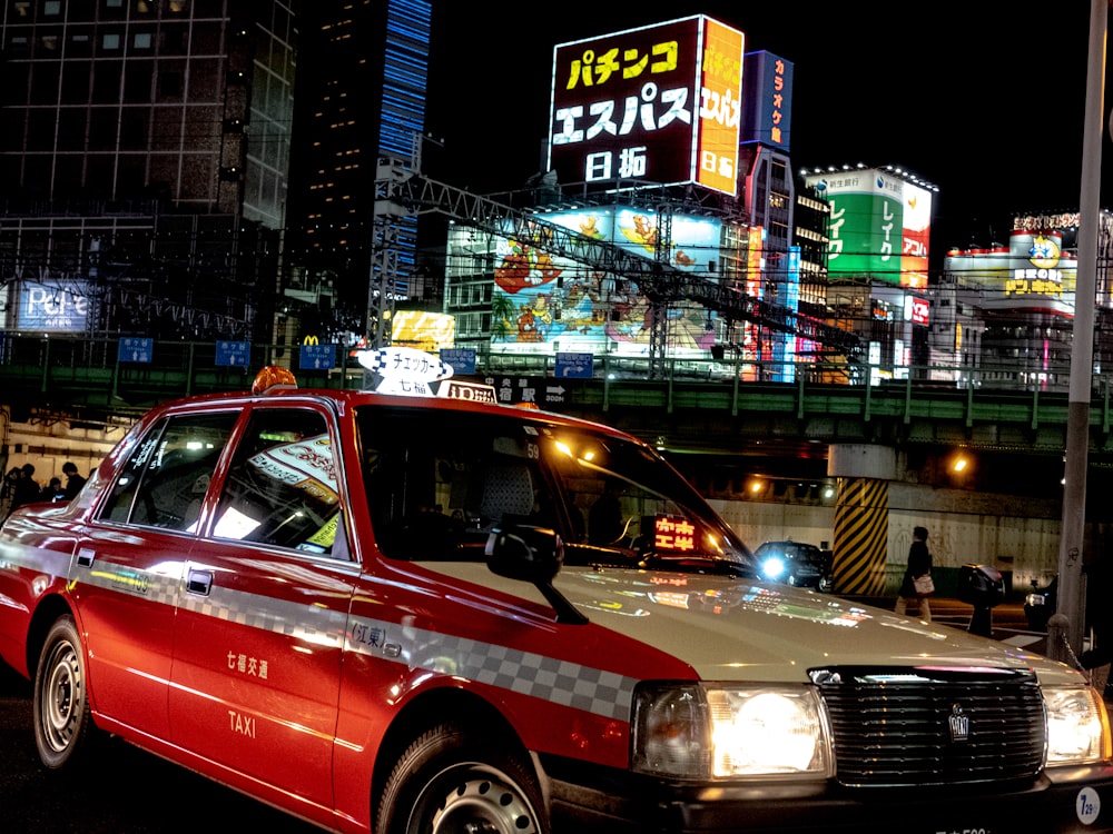 a taxi cab driving down a city street at night