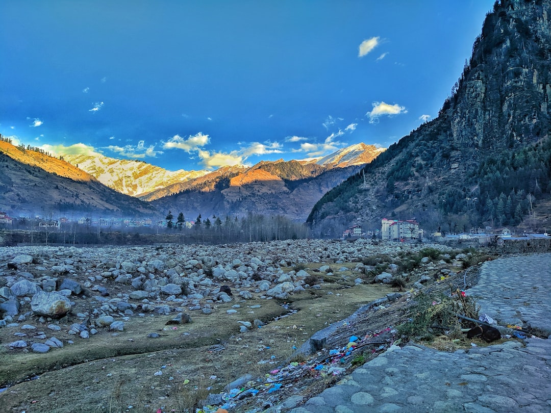 a mountain valley with a river running through it, Riverside view of Manali