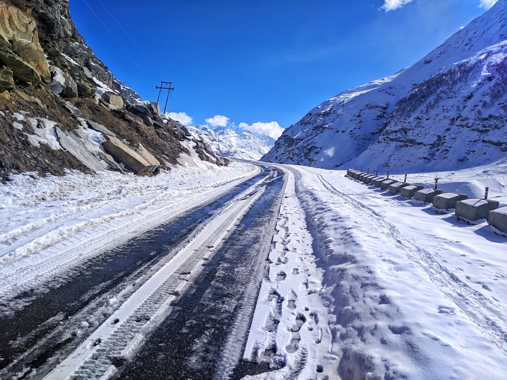 a snow covered road with a mountain in the background