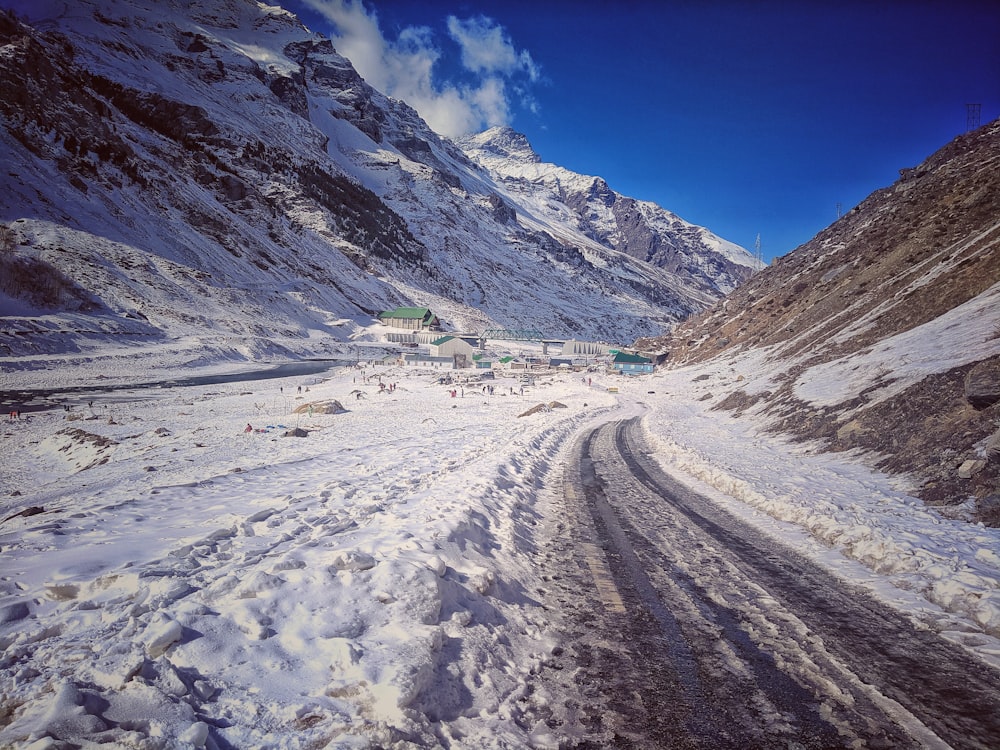 a snow covered road with a mountain in the background