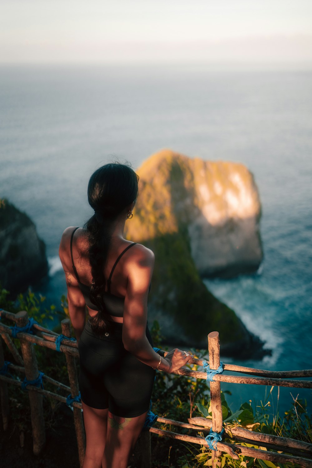 a woman in a bathing suit looking out over the ocean