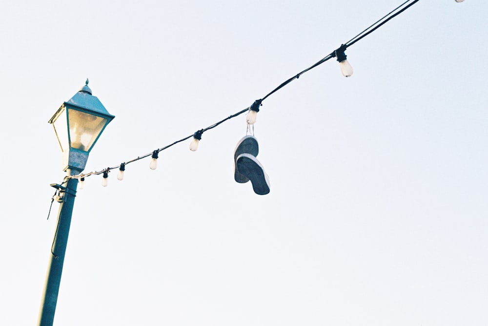 a pair of shoes hanging from a street light