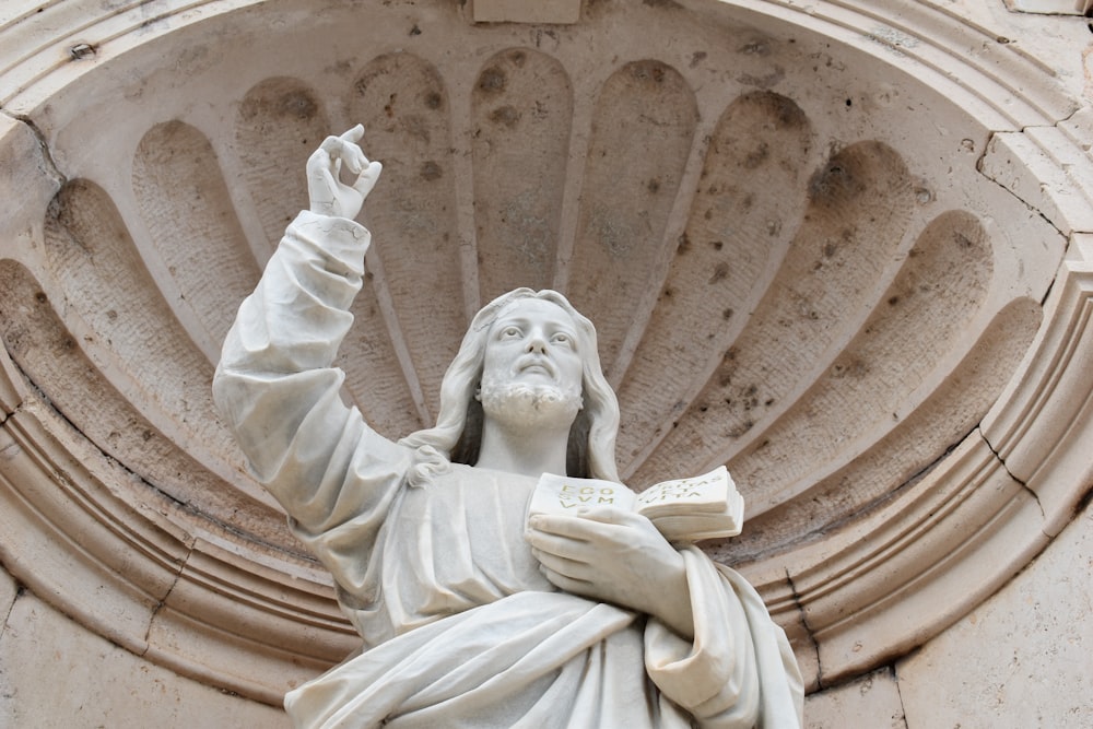 eine Statue einer Person, die ein Buch hält