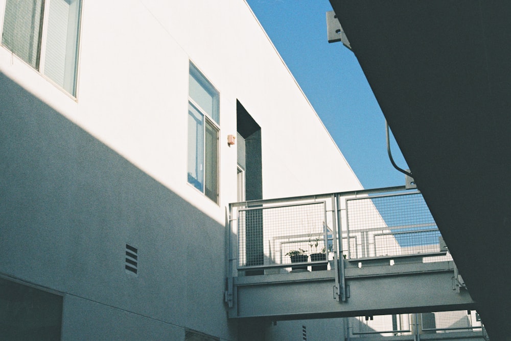 a white building with a balcony next to it