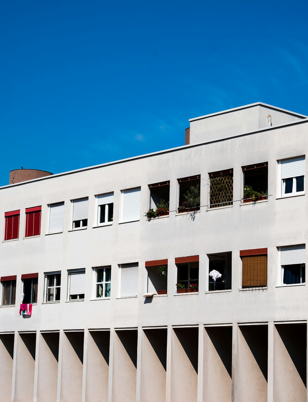 a white building with red shutters and windows