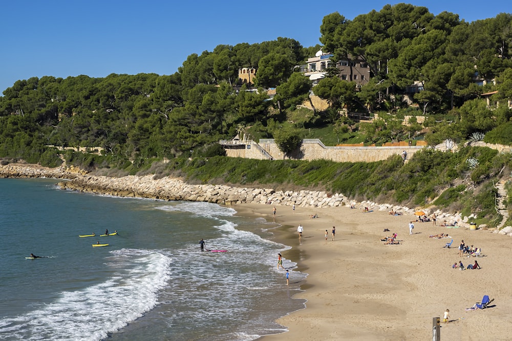 a beach with people on it and a hill in the background