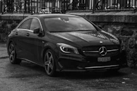 a black mercedes cla parked in front of a building