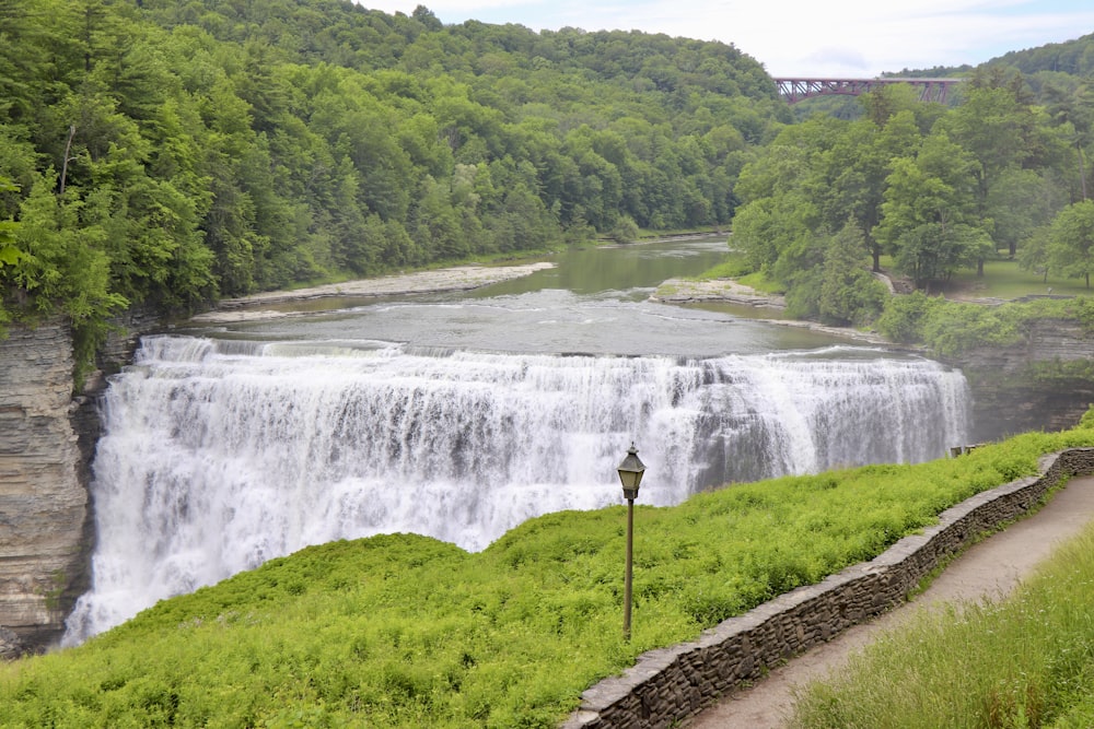 a large waterfall in the middle of a lush green forest