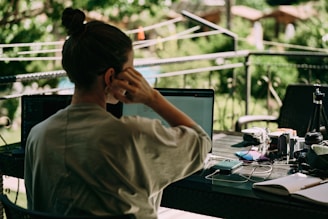 a woman sitting at a table with a laptop computer