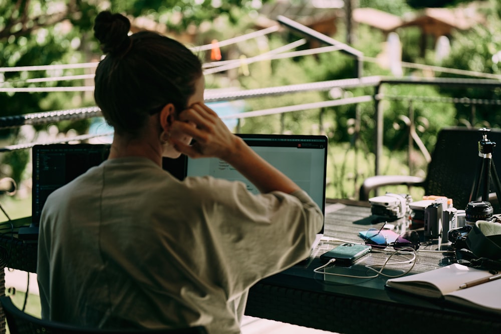 uma mulher sentada em uma mesa com um computador portátil