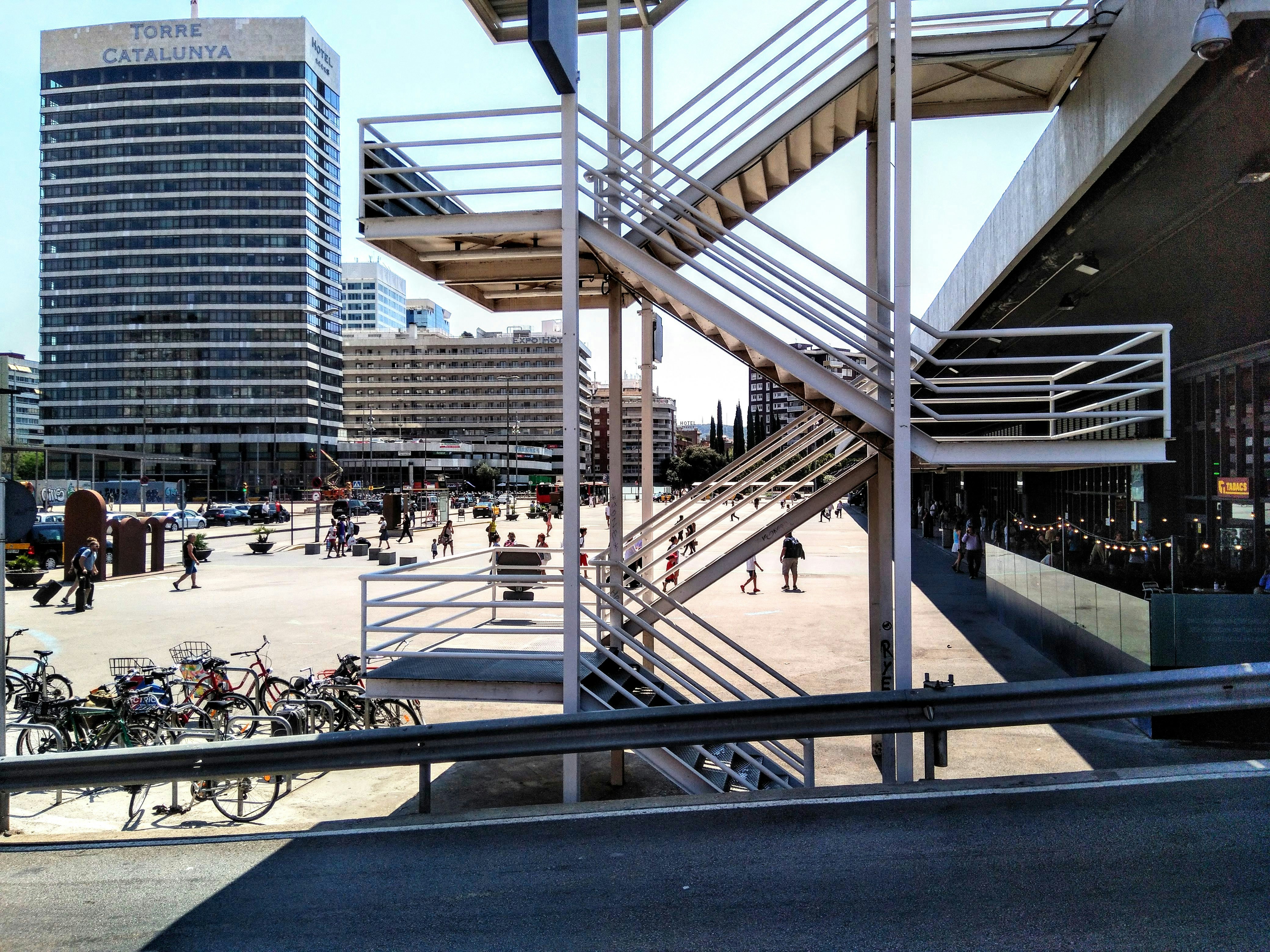 a group of people walking down a street next to tall buildings