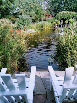 A serene garden scene with a small pond and seating area.