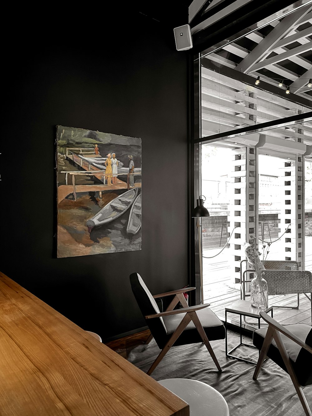 a room with a table, chairs and a painting on the wall