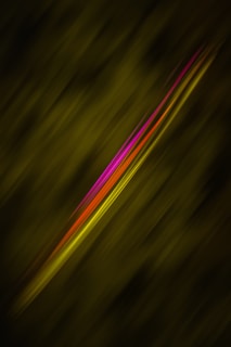A dynamic composition featuring diagonal streaks of vibrant magenta, red, and yellow set against a dark green, blurred background. The colorful lines appear as if they are moving swiftly across the frame.