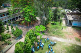 Team members in blue uniforms collaborating outdoors in front of a corporate building.