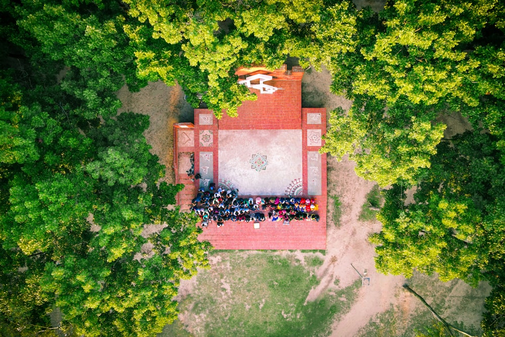 an aerial view of a red building surrounded by trees