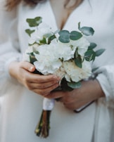 Close-up of a quinceañera's delicate hands holding a bouquet of fresh flowers.