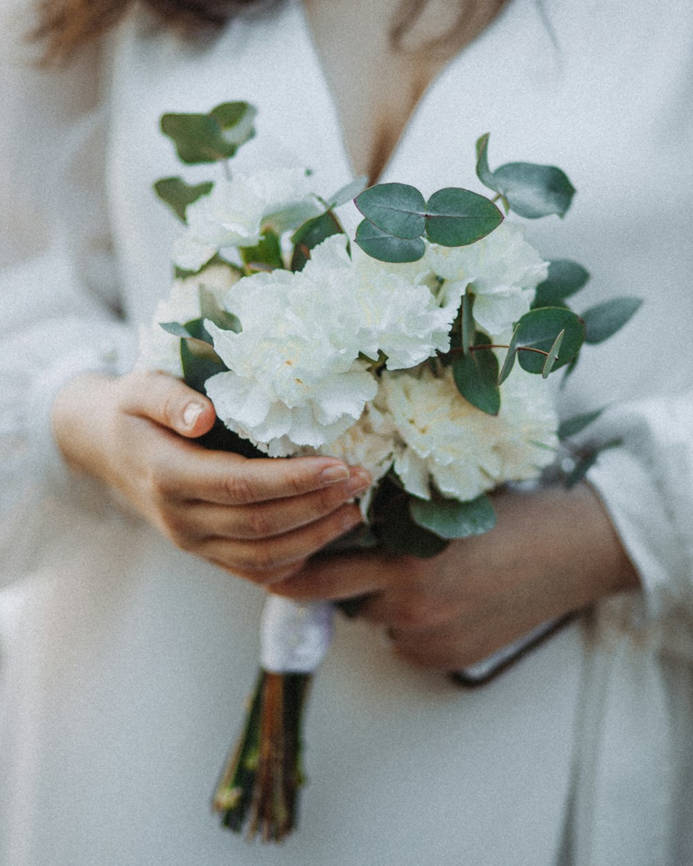 a close up of a person holding a bouquet of flowers