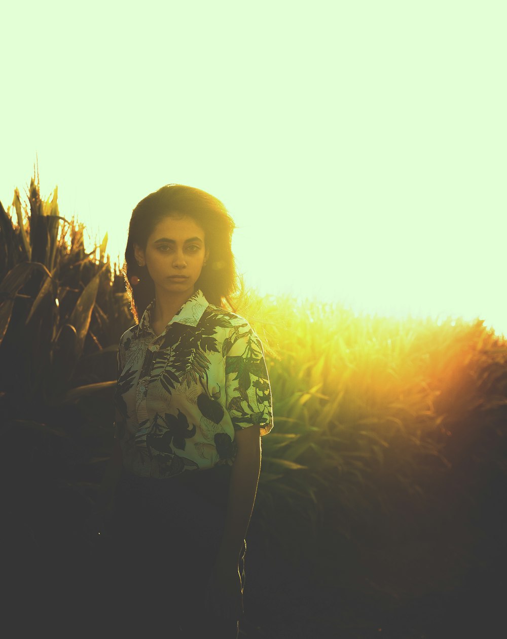 a woman standing in front of a field of corn