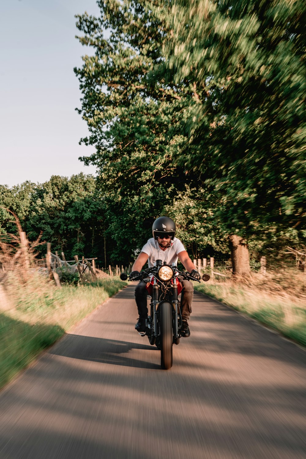 a man riding a motorcycle down a dirt road