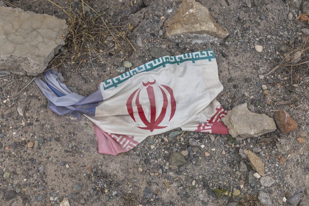 a flag laying on the ground next to rocks