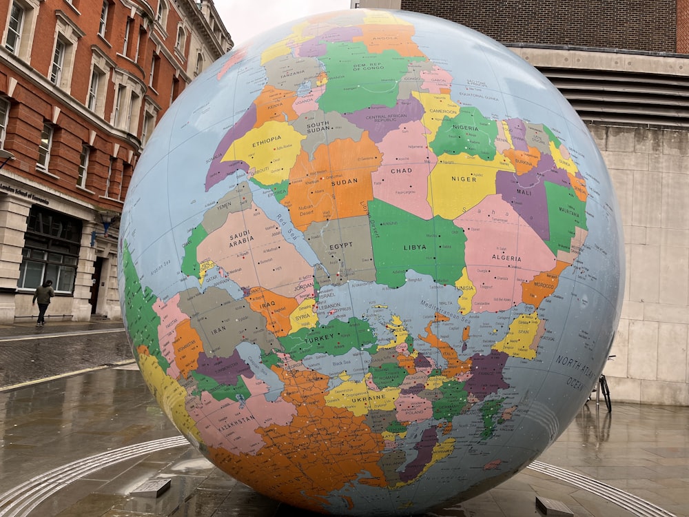 a large globe sitting in the middle of a street