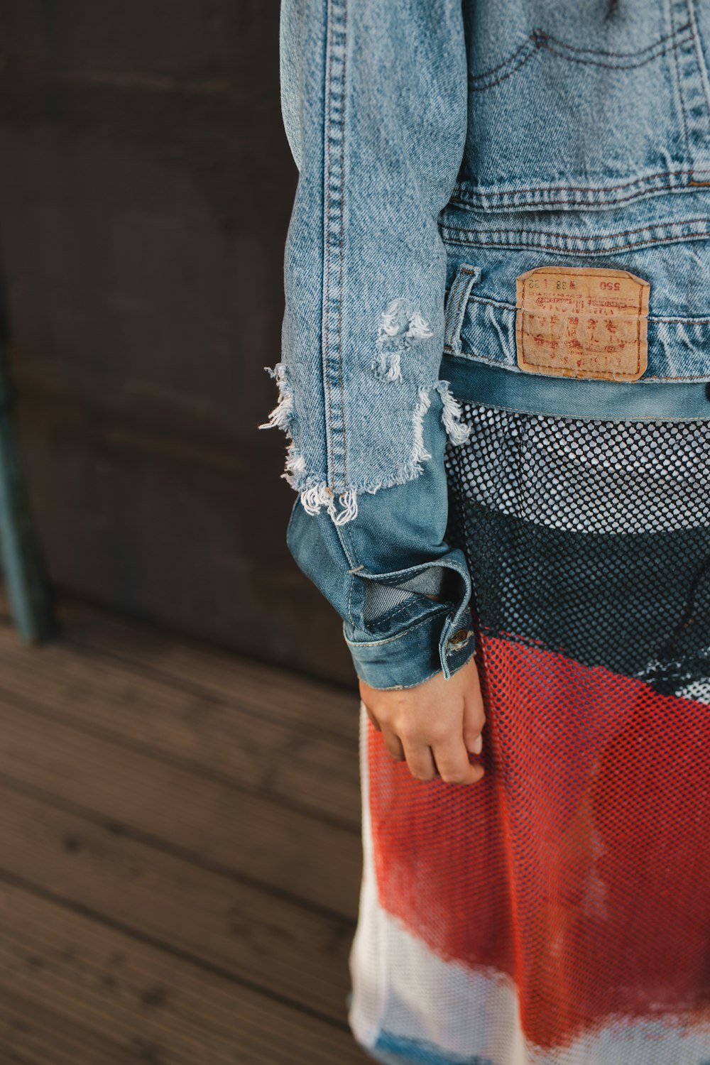 a person wearing a jean jacket with a patch on it
