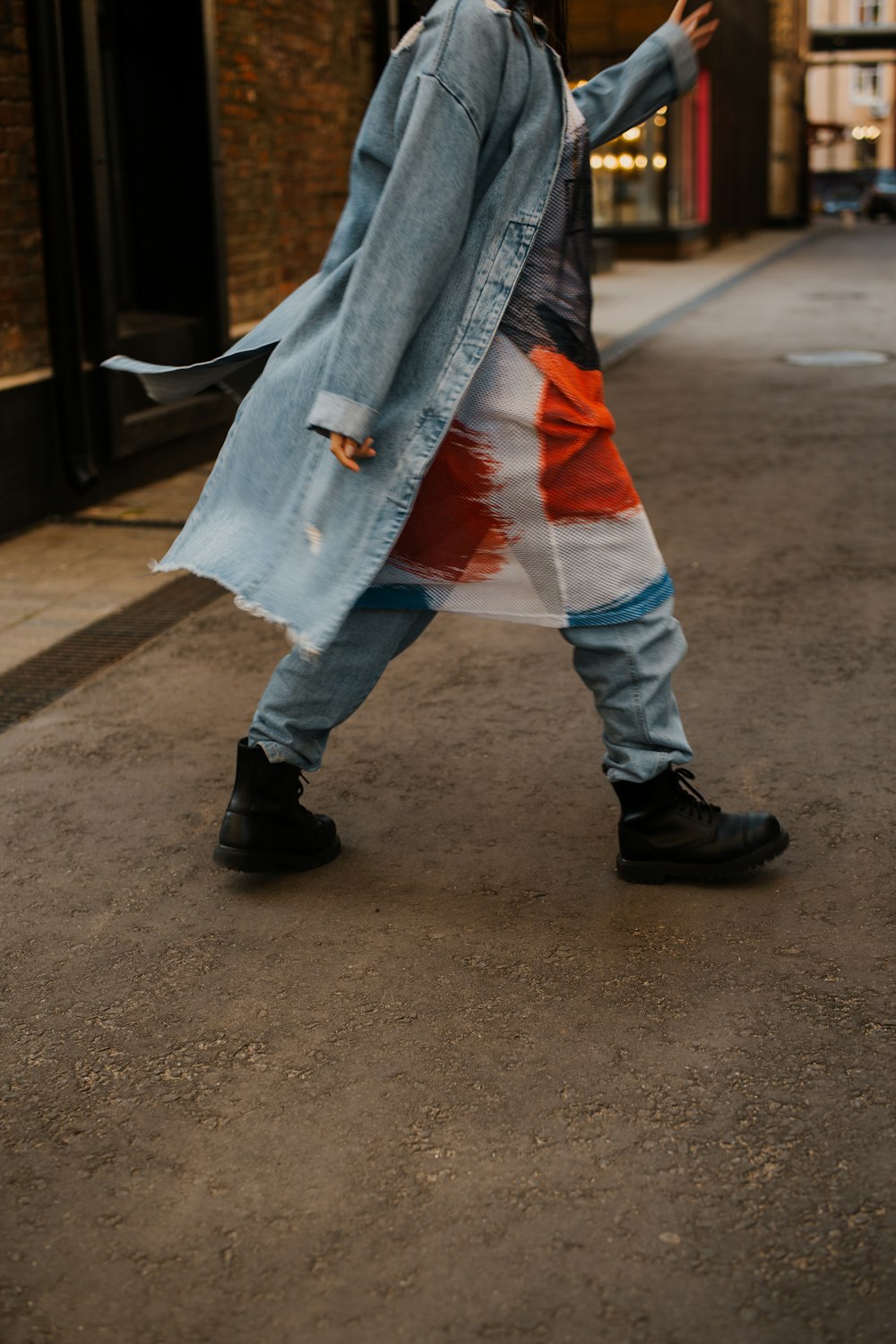 a person walking down a street with a coat on