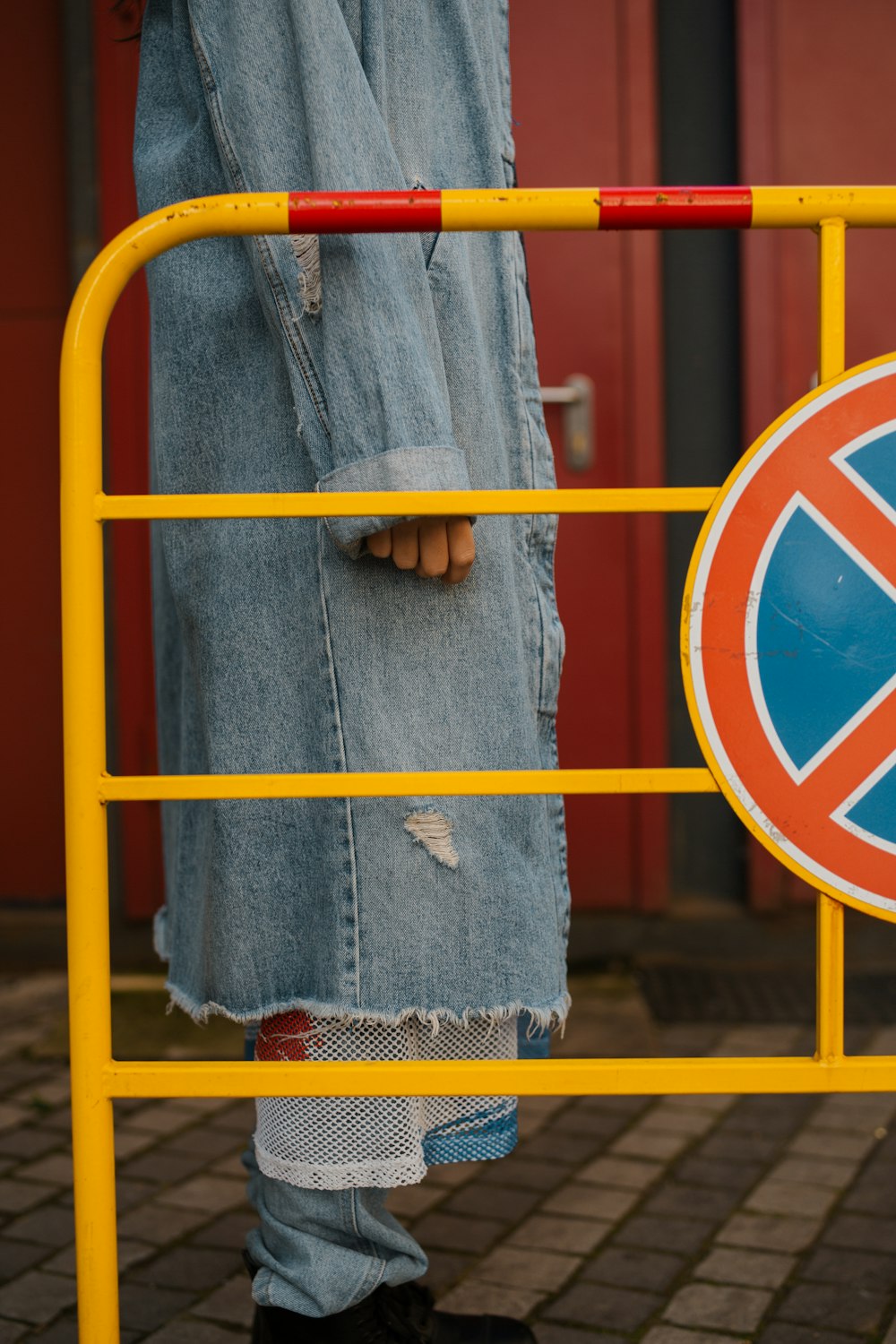 a person standing in front of a yellow gate