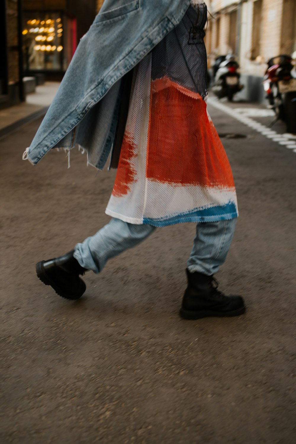 a person walking down a street carrying a jacket
