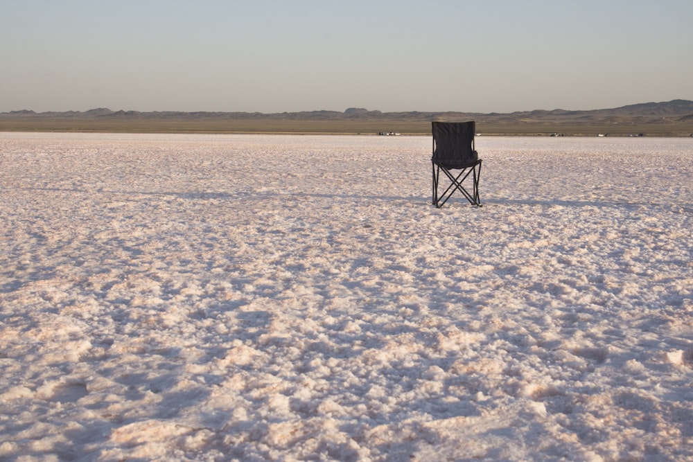 a chair sitting in the middle of a snowy field