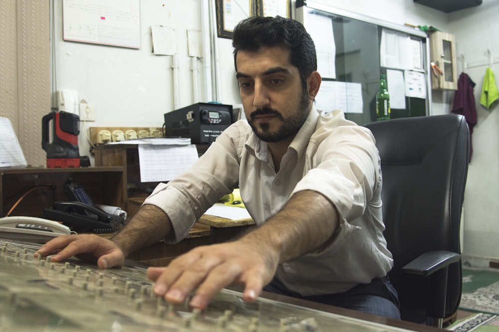 a man sitting at a desk typing on a keyboard