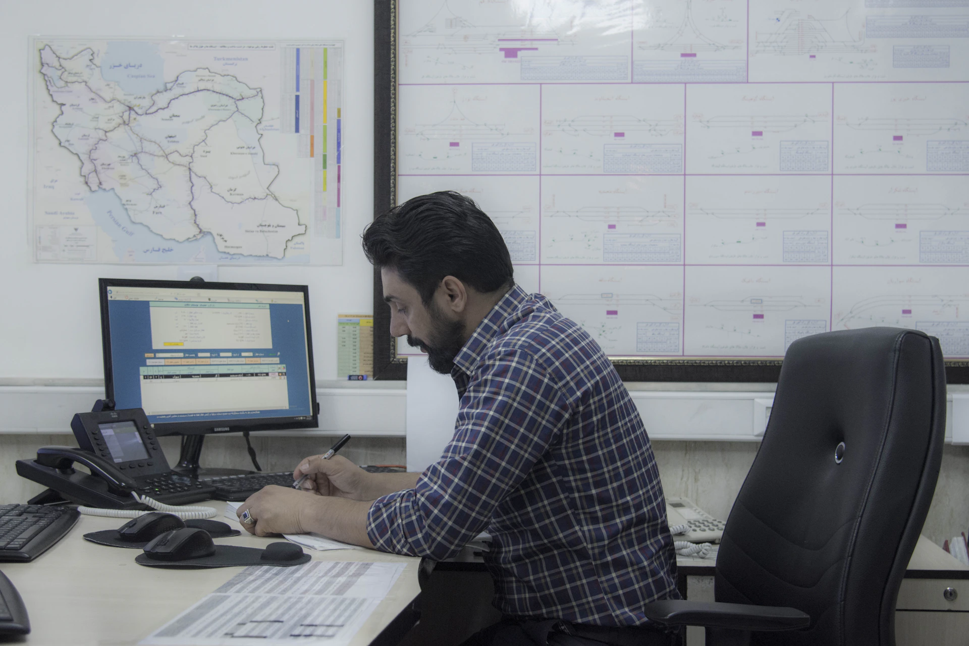 a man sitting at a desk working on a computer