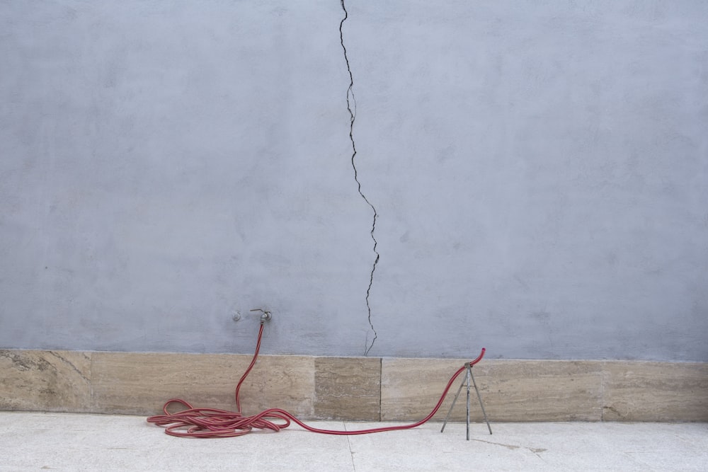 a crack in a wall with a red cord attached to it