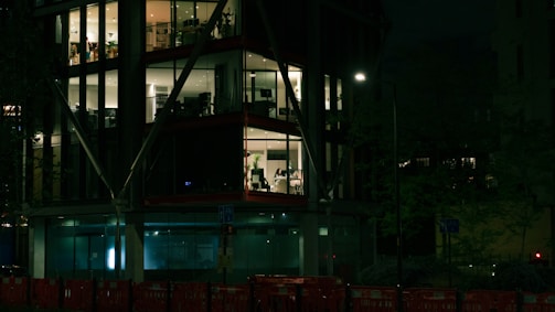 Evening shot of a completed office space with elegant glass walls and warm interior lighting.