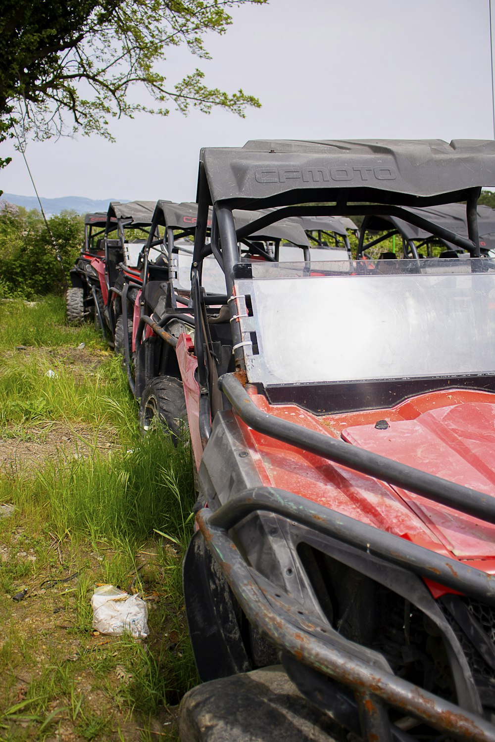 a line of off road vehicles parked in a field