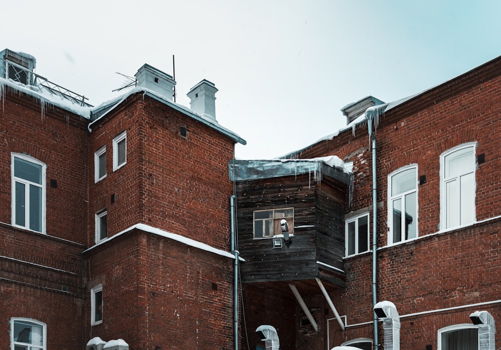 a red brick building with snow on the ground