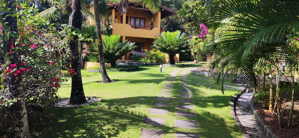 a house surrounded by palm trees and flowers