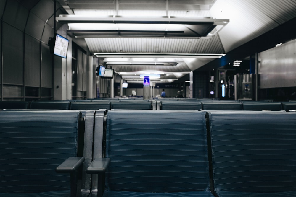 uma fileira de assentos vazios em um aeroporto