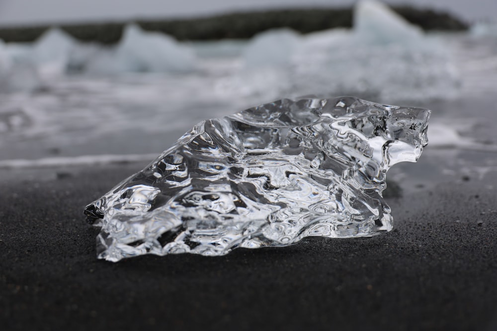 a piece of ice sitting on top of a beach