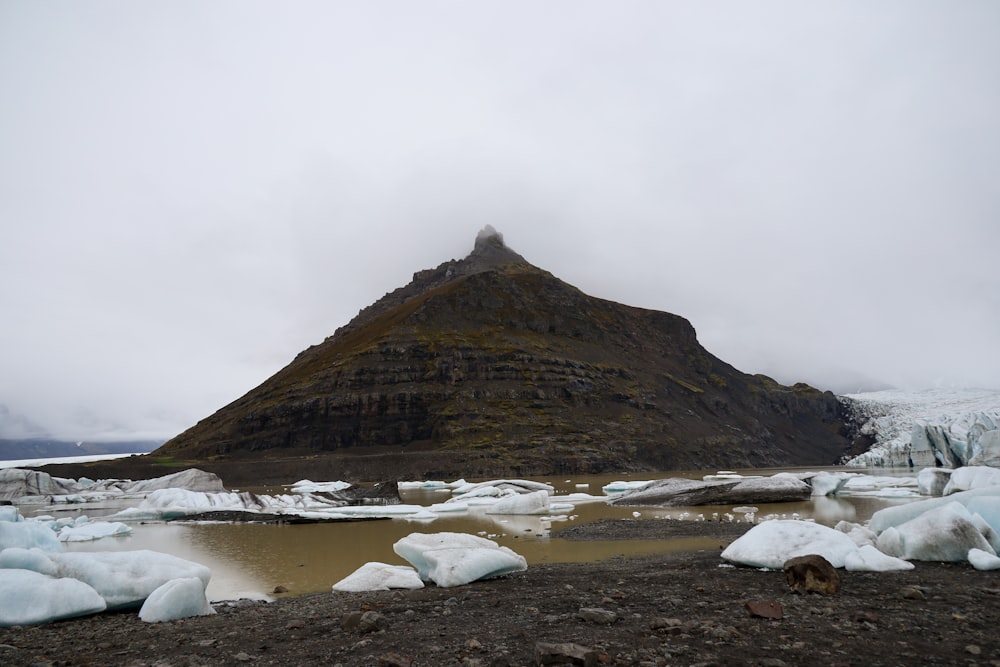 una montaña cubierta de nieve junto a un cuerpo de agua