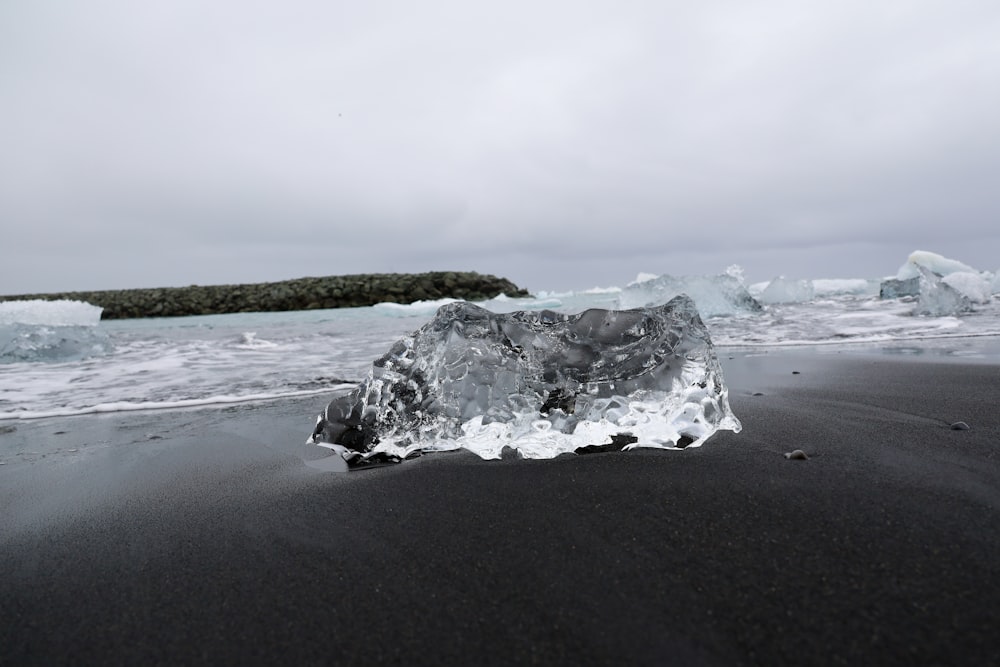 an iceberg on a black sand beach near the ocean