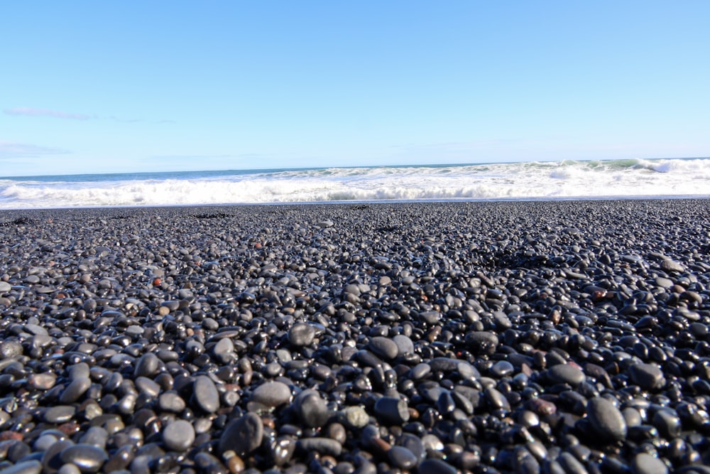 a rocky beach with a wave coming in to shore